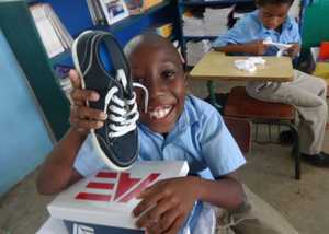 Child opening a pair of donated shoes