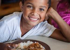 Child sitting with a donated meal